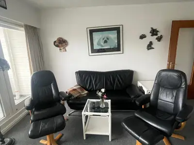 Ein modernes Wohnzimmer mit schwarzem Ledermöbel und einem kleinen Tisch