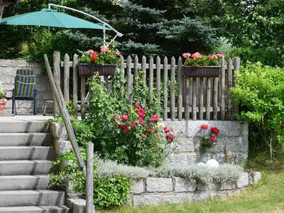 Terrasse vor der Wohnung mit Gartenmöbeln und Sonnenschirm