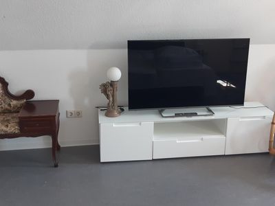 Schlafzimmer mit Fernseher und Ruhebank