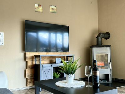 Wohnzimmer mit Ofen Elektrokamin und Balkon