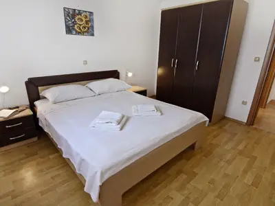 Das Schlafzimmer mit Doppelbett, Nachttische mit Nachttischlampen, Kleiderschrank.