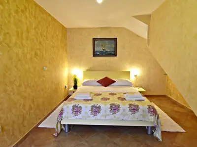 Das Schlafzimmer mit Doppelbett, zwei Nachttische mit Nachttischlampen.