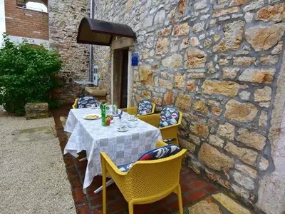 Die Terrasse am Eingang mit Gartentisch und Stühlen.