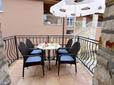 Der Balkon ist mit Gartentisch und Stühlen, Sonnenschirm ausgestattet.
