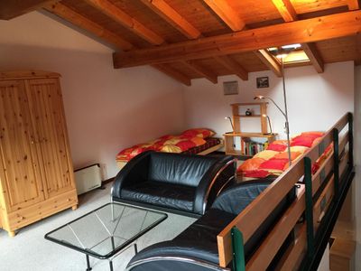 Wohnbereich mit 2 Betten, Sitzecke mit TV und WiFi und toller Aussicht über die Dächer auf den Luganersee
