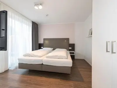 Schlafzimmer mit Doppelbett und TV