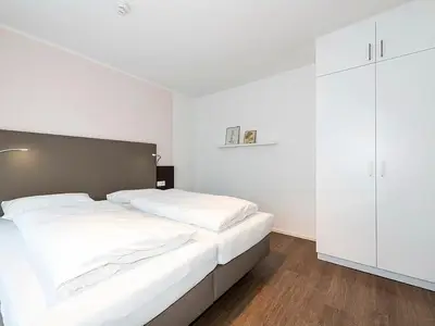 Schlafzimmer mit Doppelbett und Kleiderschrank