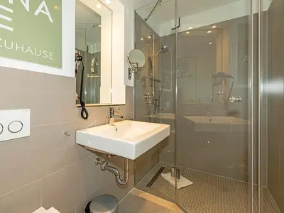 Badezimmer mit Dusche, Waschtisch, WC und Spiegel