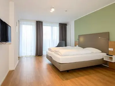 Schlafzimmer mit Doppelbett und TV