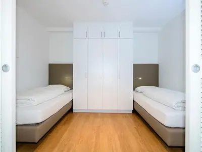 Schlafzimmer mit Einzelbetten und Kleiderschrank