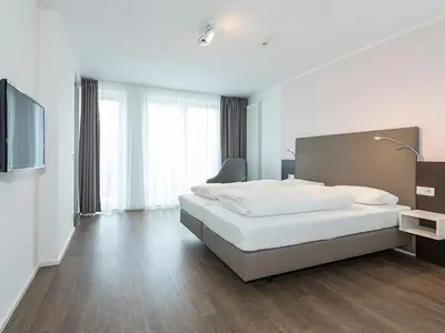 Schlafzimmer mit Doppelbett und TV