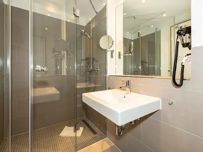 Badezimmer mit Dusche, Waschtisch und Spiegel