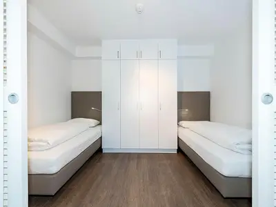 Schlafzimmer mit Einzelbetten und Kleiderschrank
