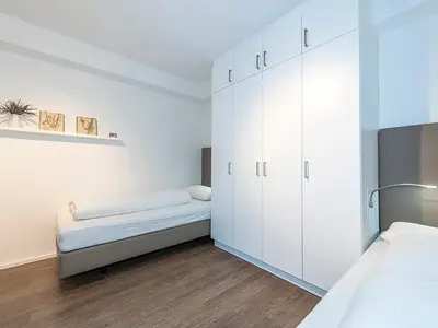 Schlafzimmer mit Einzelbetten und Kleiderschrank