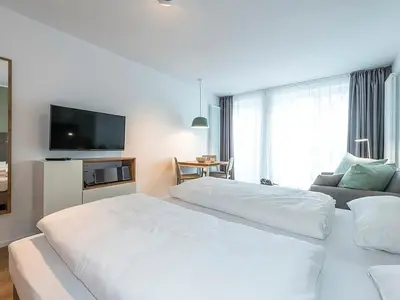 Wohn-Schlafbereich mit Doppelbett und TV