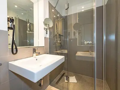 Badezimmer mit Dusche, Waschtisch und Spiegel