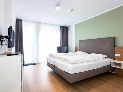 Schlafzimmer mit Doppelbett und TV