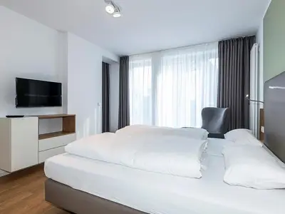 Schlafzimmer mit Doppelbett und TV