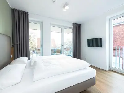Schlafzimmer mit Doppelbett und TV