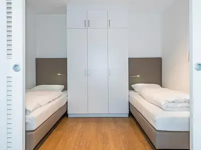 Schlafzimmer mit zwei Einzelbetten und Kleiderschrank