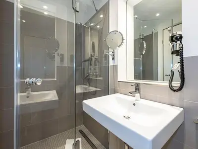 Badezimmer mit Dusche, Waschtisch und Spiegel