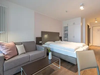 Wohn-Essbereich mit Couch und Doppelbett