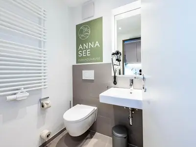 Badezimmer mit Dusche, WC, Waschtisch und Spiegel