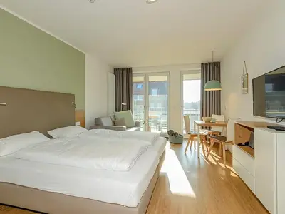 Wohn-Essbereich mit Couch und Doppelbett