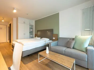 Wohn-Schlafbereich mit Couch und Doppelbett