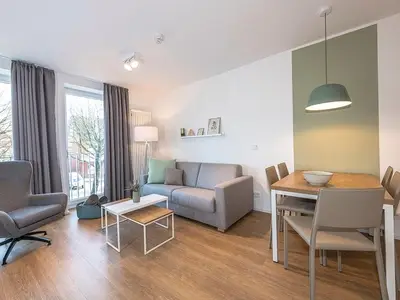 Wohnbereich mit Couch, Sesseln und Esstisch