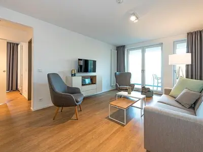 Wohnzimmer mit Couch, Couchtisch,Sessel und TV