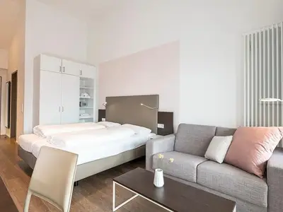 Wohn-Schlafbereich mit Doppelbett und TV