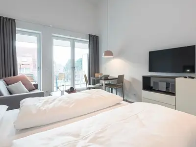 Wohn-Schlafbereich mit Doppelbett und TV