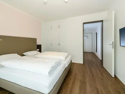 Schlafzimmer mit Doppelbett, Kleiderschrank und TV