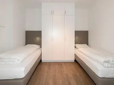 Schlafzimmer mit zwei Einzelbetten und Kleiderschrank