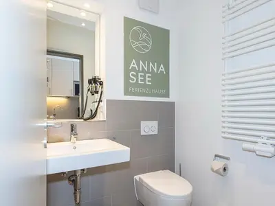 Badezimmer mit Waschtisch, WC, Fön und Spiegel