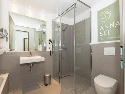 Badezimmer mit Dusche, Waschtisch, WC und Spiegel
