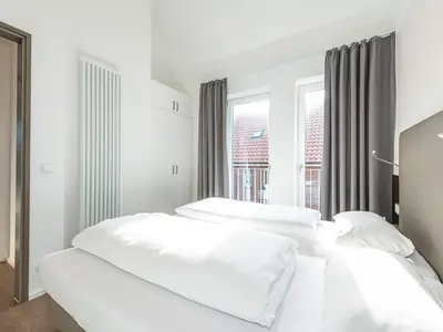 Schlafzimmer mit Doppelbett und Kleiderschrank