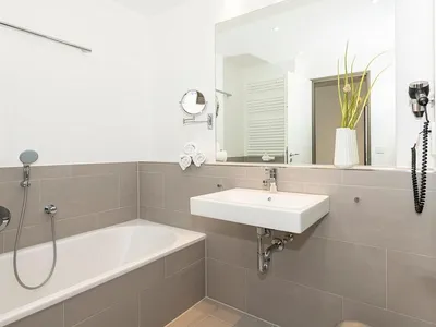 Badezimmer mit Badewanne, Waschtisch und Spiegel