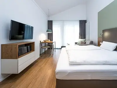 Wohn-Schlafbereich mit Doppelbett und TV