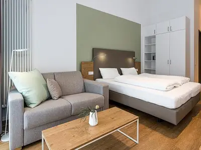 Wohn-Schlafbereich mit Doppelbett, Schlafsofa und Kleiderschrank