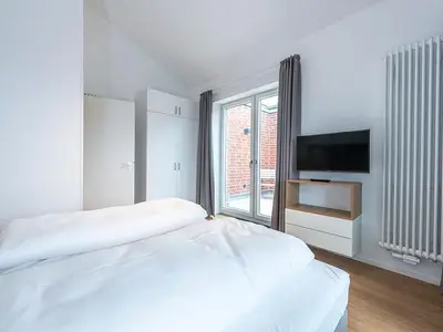 Schlafzimmer mit Doppelbett und TV
