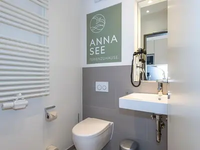 Badezimmer mit Waschtisch, WC, Fön und Spiegel