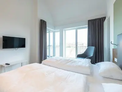 Schlafzimmer mit Boxspringbett und TV