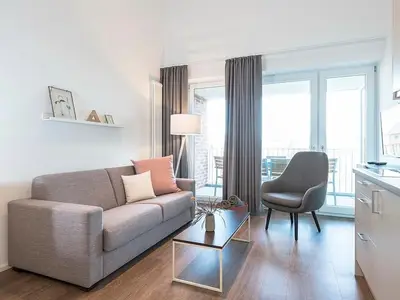 Wohnzimmer mit Schlafcouch und Sessel