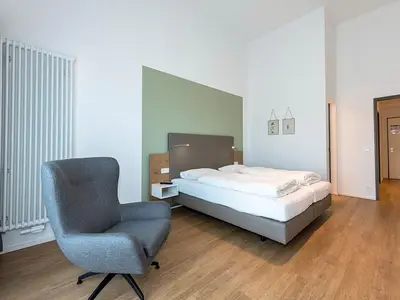 Schlafzimmer mit Doppelbett und Sessel