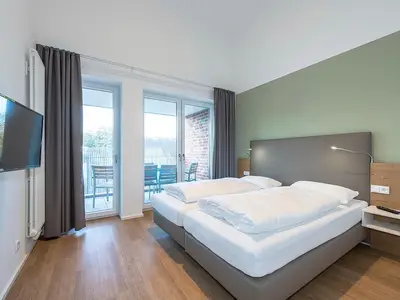 Schlafzimmer mit Boxspringbett und TV