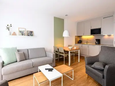 Wohn/Essbereich mit Couch, Sessel, Esstisch und Küchenzeile