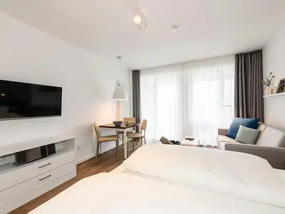 Wohn/Essbereich mit Doppelbett, Couch, Esstisch und TV