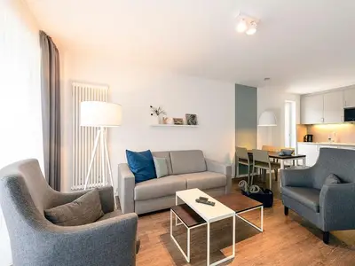 Wohn/Essbereich mit Couch, Sesseln, Esstisch und Küchenzeile